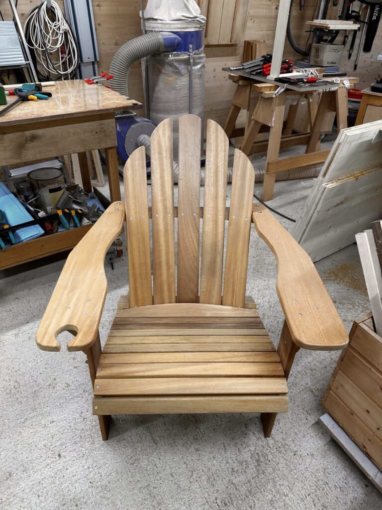 Frontansicht eines Adirondack-Stuhls mit gerundeter Rückenlehne und breiten Armauflagen.